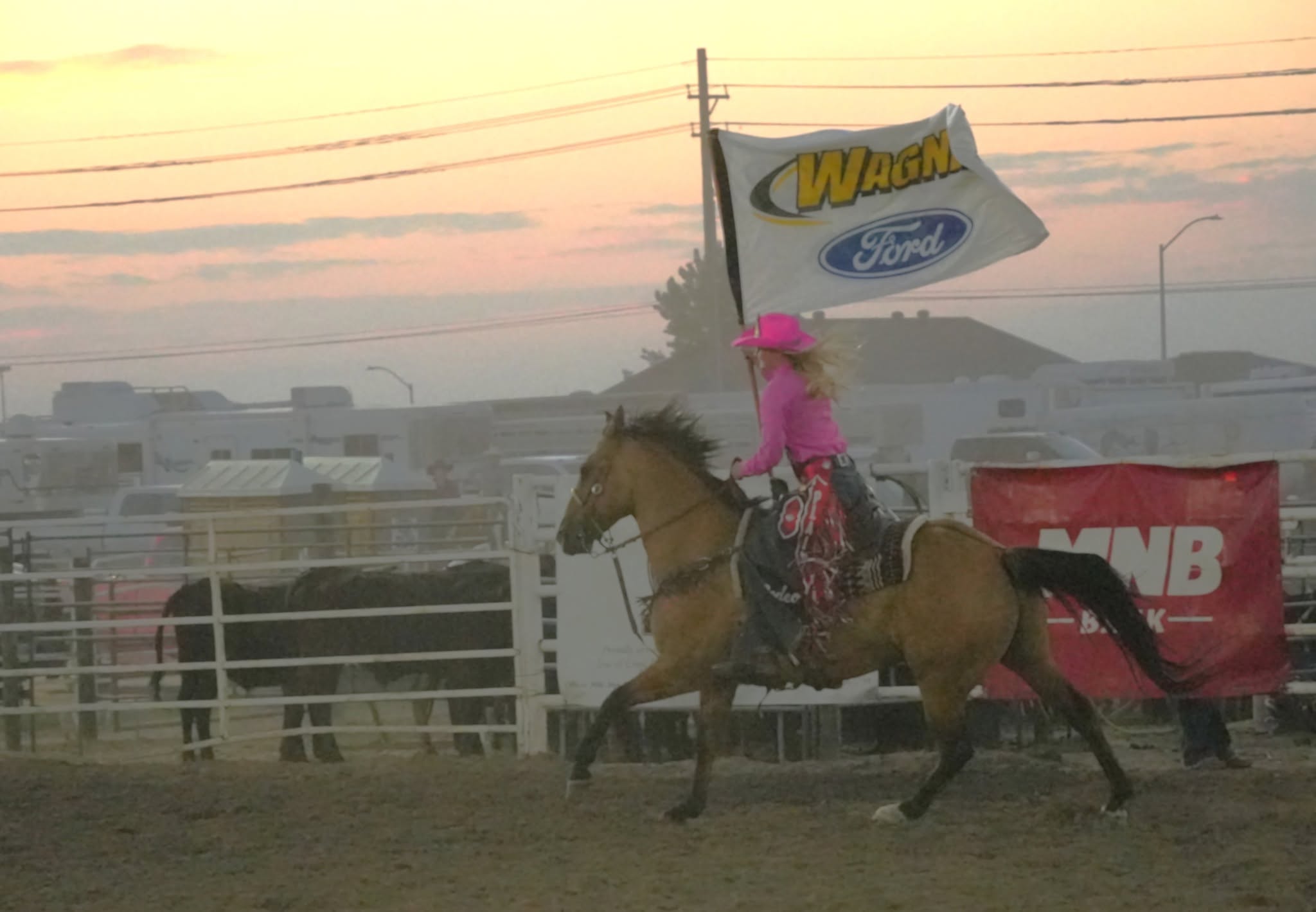 Rodeo rider carrying a Wagner Ford flag